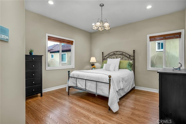 bedroom featuring light hardwood / wood-style floors and a chandelier