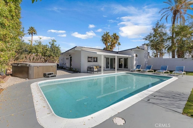 view of pool with a patio area, a fenced in pool, a hot tub, and fence