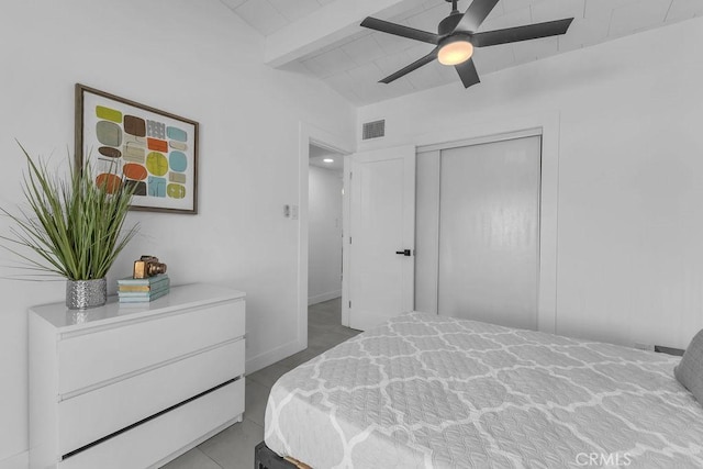 bedroom with visible vents, baseboards, ceiling fan, lofted ceiling with beams, and a closet