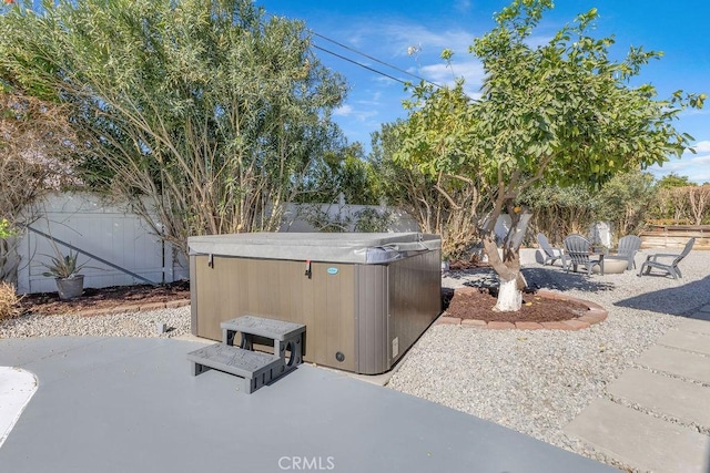 view of yard with a patio area, a fenced backyard, and a hot tub