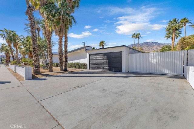 garage featuring a gate, fence, and a mountain view