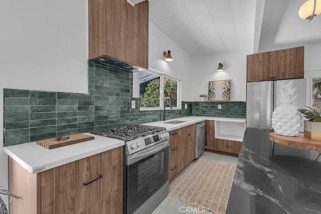 kitchen featuring decorative backsplash, modern cabinets, appliances with stainless steel finishes, and a sink