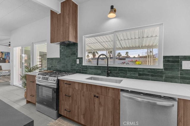 kitchen with a sink, light countertops, tasteful backsplash, and stainless steel appliances