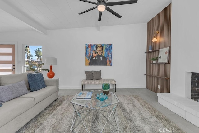 living area featuring beamed ceiling, ceiling fan, a fireplace, and baseboards