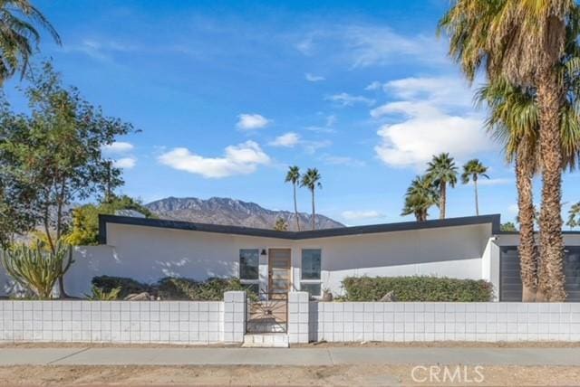 view of front of property with a fenced front yard and stucco siding