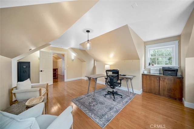 office area featuring light wood-style flooring, baseboards, and vaulted ceiling