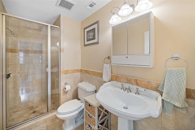 full bath with toilet, a stall shower, visible vents, and a sink