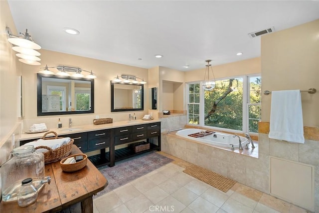 full bath featuring tile patterned flooring, a garden tub, a sink, visible vents, and double vanity