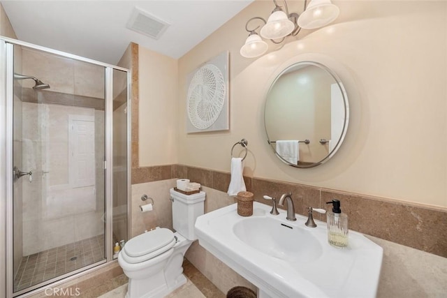 bathroom featuring visible vents, tile walls, toilet, a shower stall, and a notable chandelier