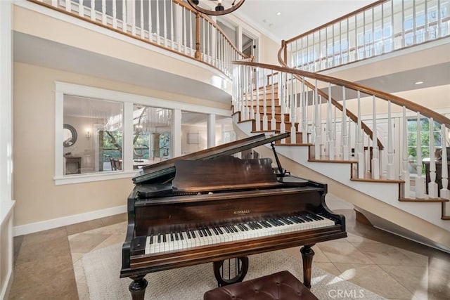 interior space with baseboards, a high ceiling, and tile patterned floors