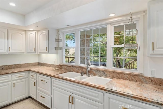 kitchen with light stone counters, recessed lighting, a sink, and white cabinets