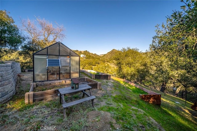 view of yard featuring an outbuilding, an exterior structure, a garden, and fence