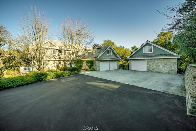 view of front of house featuring stone siding and concrete driveway