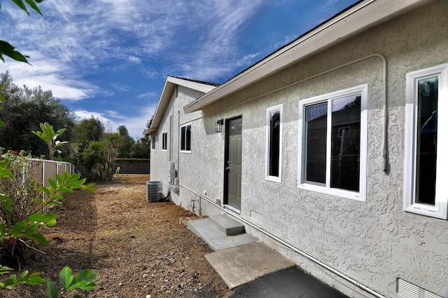 view of side of property with central air condition unit