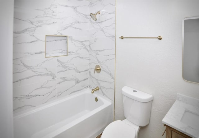 full bathroom featuring tiled shower / bath, vanity, and toilet