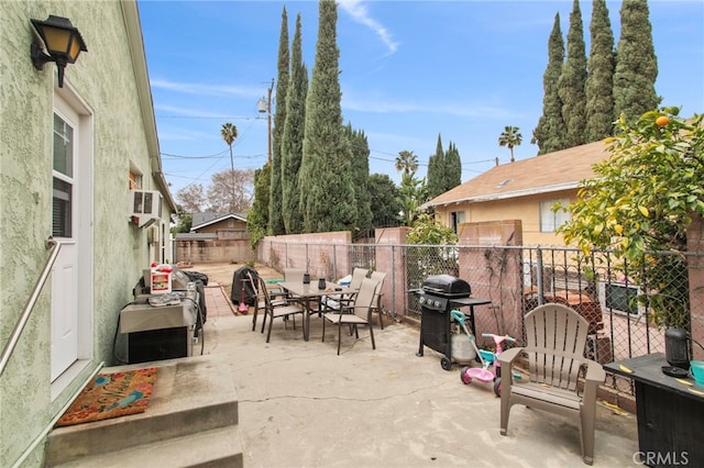 view of patio with grilling area and a wall unit AC