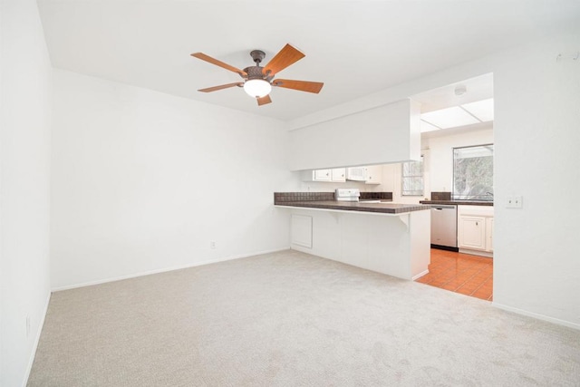 kitchen with white cabinetry, a kitchen breakfast bar, stove, kitchen peninsula, and light carpet