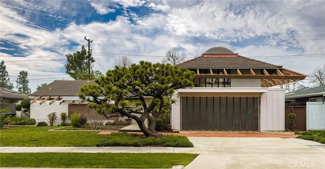 view of front of house featuring a balcony and a front yard