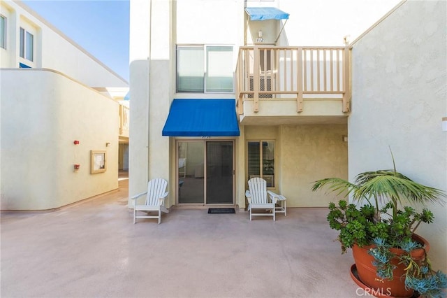 711 Pacific Coast Unit 313, Huntington Beach, CA 92648 - rear view of house featuring a patio area, a balcony, and stucco siding