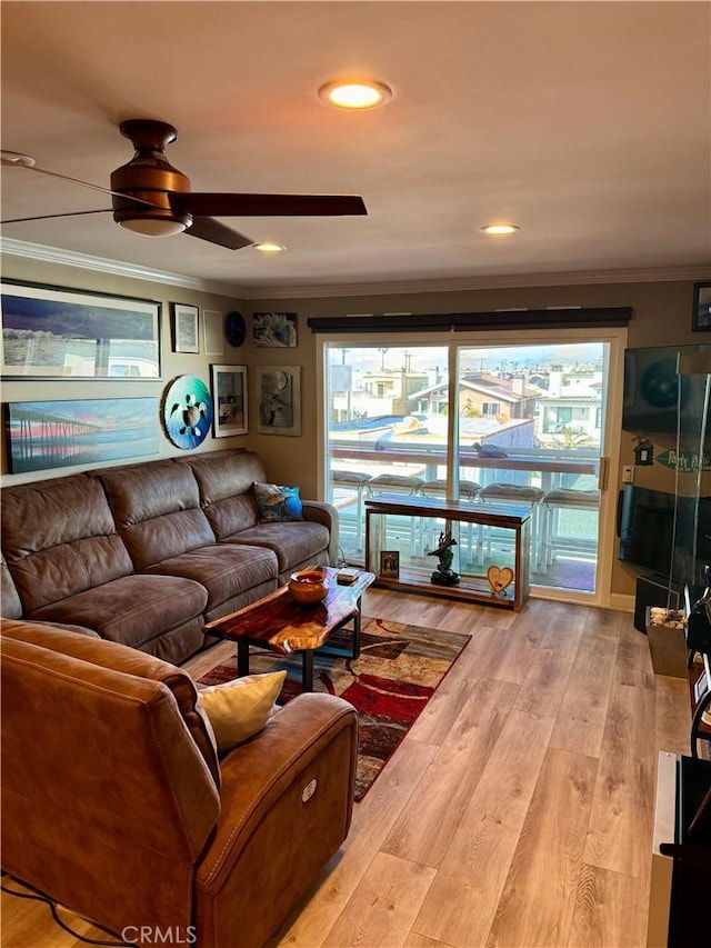 living room featuring hardwood / wood-style flooring, crown molding, and ceiling fan