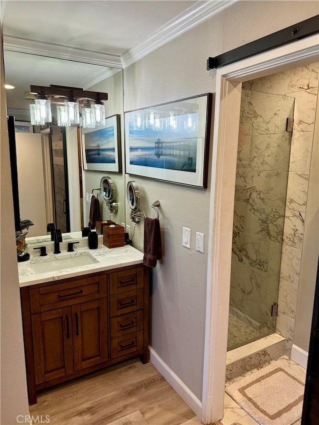 bathroom with crown molding, vanity, hardwood / wood-style flooring, and a tile shower