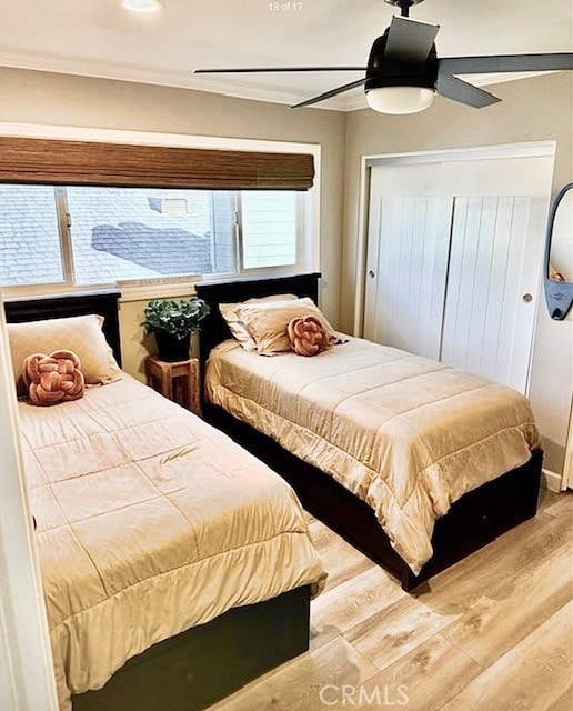 bedroom featuring crown molding, a ceiling fan, a closet, and wood finished floors