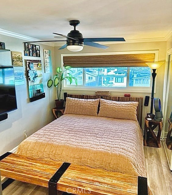 bedroom featuring crown molding, ceiling fan, and wood finished floors