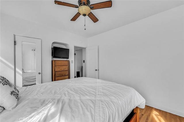 bedroom with ceiling fan, baseboards, and wood finished floors