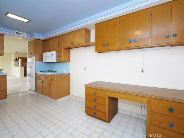 kitchen with white appliances and built in desk