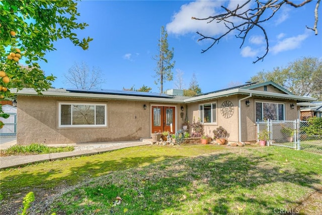 view of front of house featuring french doors, a front lawn, and solar panels