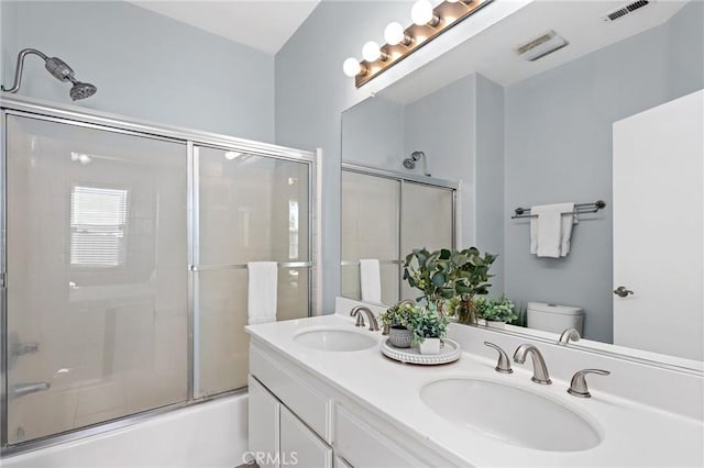 full bathroom featuring enclosed tub / shower combo, vanity, and toilet