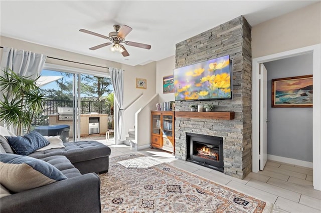 living room featuring a stone fireplace and ceiling fan