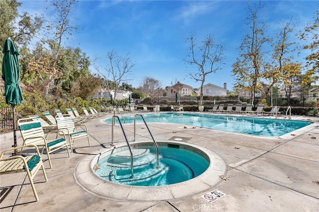 view of pool with a hot tub and a patio area