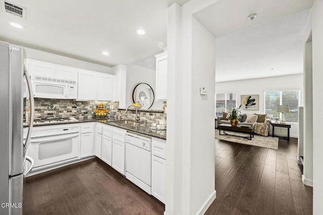 kitchen featuring sink, appliances with stainless steel finishes, dark stone countertops, white cabinetry, and dark hardwood / wood-style flooring