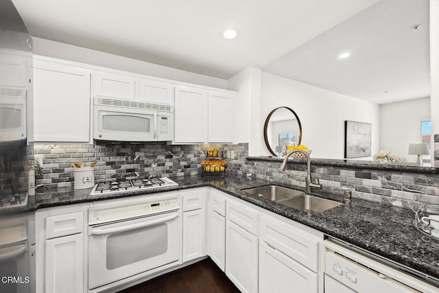 kitchen with white appliances, dark stone countertops, sink, and white cabinets