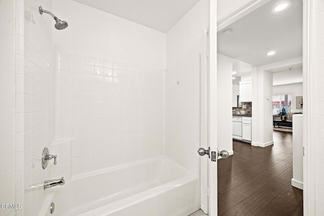 bathroom featuring decorative backsplash,  shower combination, and wood-type flooring