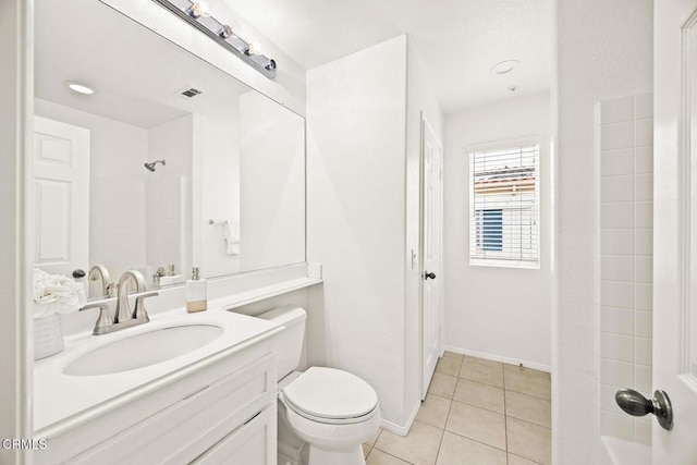 bathroom featuring tile patterned flooring, walk in shower, vanity, and toilet