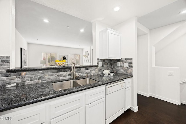 kitchen with tasteful backsplash, dishwasher, sink, dark stone countertops, and white cabinets