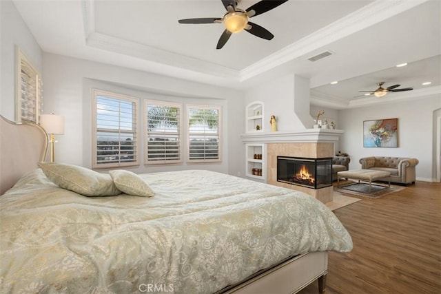 28622 Point Loma, Laguna Niguel, CA 92677 - bedroom with a tray ceiling, wood finished floors, recessed lighting, a tiled fireplace, and crown molding