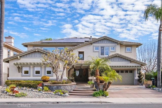 craftsman inspired home featuring a garage, concrete driveway, stucco siding, and solar panels