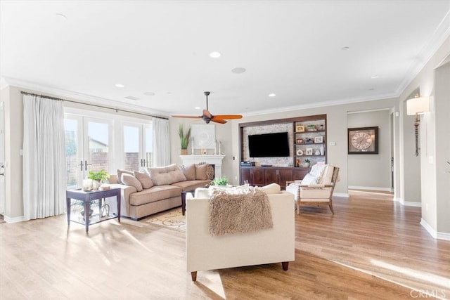 living area with recessed lighting, a ceiling fan, baseboards, light wood-style floors, and ornamental molding