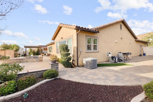 rear view of property with a patio, a fenced backyard, cooling unit, and stucco siding