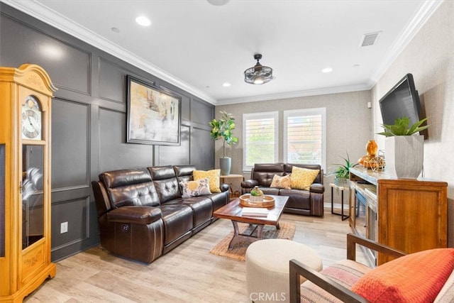 living area with crown molding, recessed lighting, a decorative wall, and light wood-style flooring