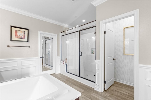 full bathroom featuring a tub, wainscoting, ornamental molding, and wood finished floors