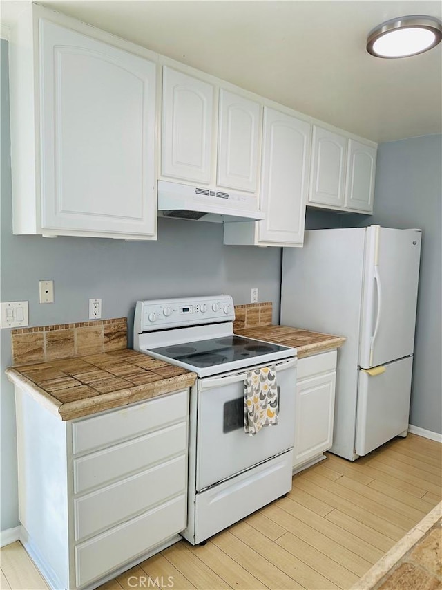 kitchen featuring white cabinetry, light wood-type flooring, and white appliances