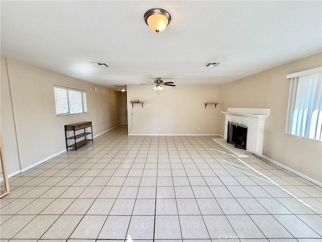 unfurnished living room featuring light tile patterned floors and ceiling fan