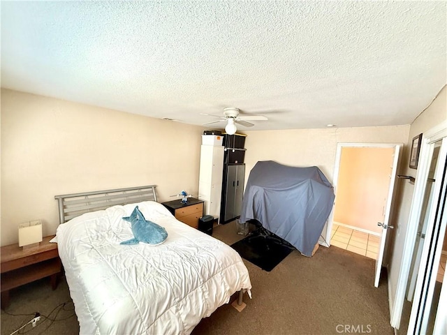 bedroom with a textured ceiling, carpet floors, and ceiling fan