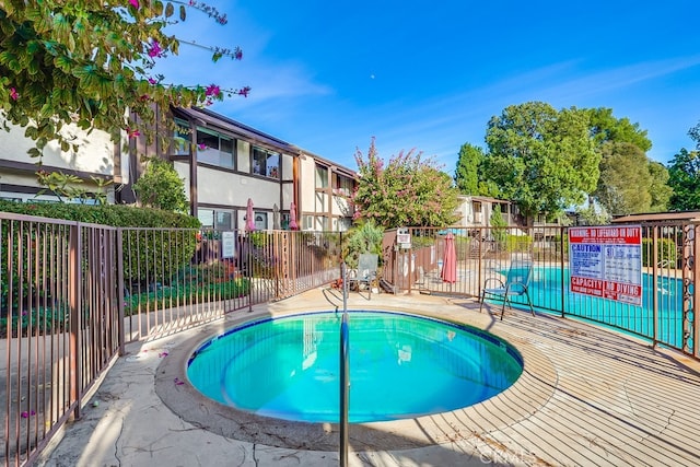 view of pool with a hot tub