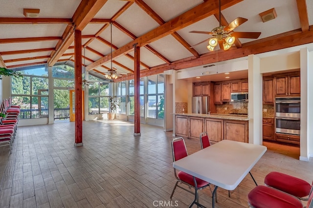 interior space featuring ceiling fan, light hardwood / wood-style floors, and lofted ceiling with beams