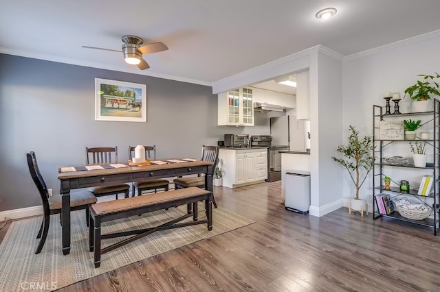 dining space with ornamental molding, wood-type flooring, and ceiling fan